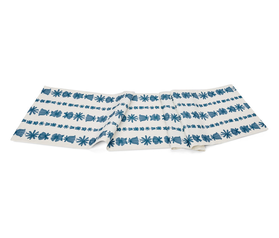 Mavi çiçek ve geometrik desenli beyaz masa örtüsü.