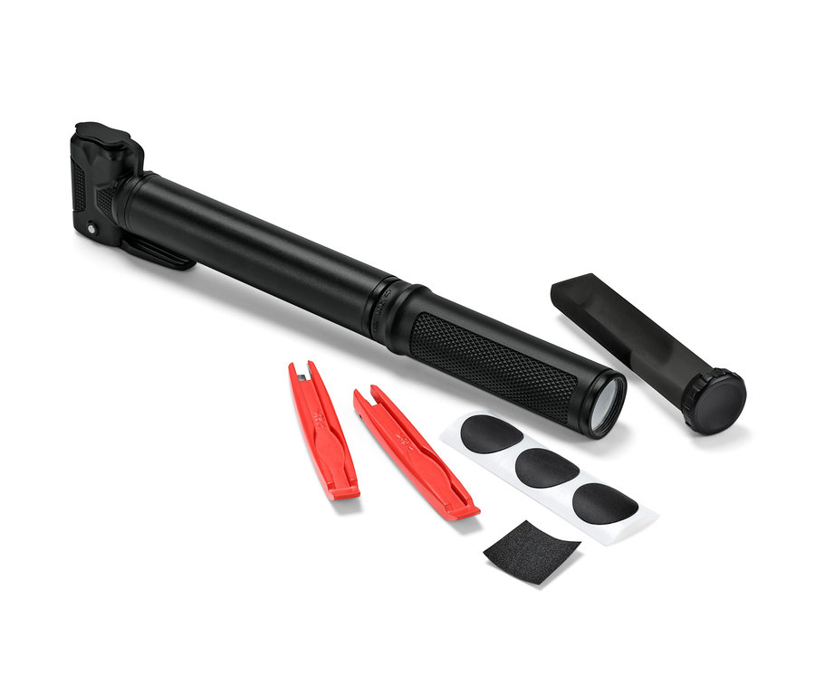 Siyah mini bisiklet pompası, iki adet kırmızı lastik levyesi, yama ve zımpara kağıdının yanında duruyor.