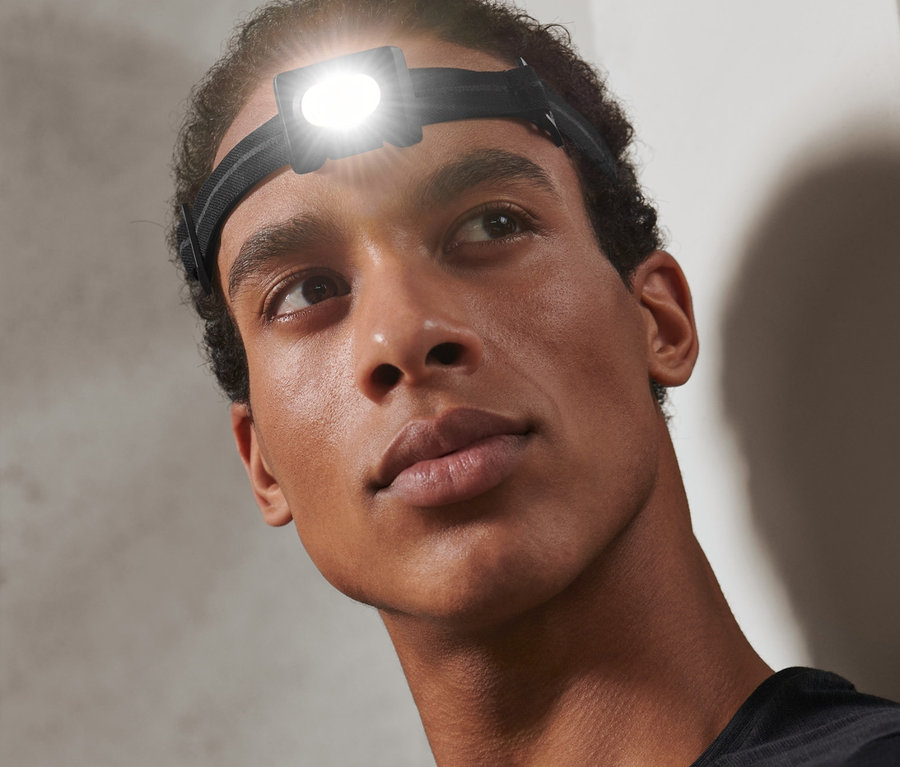 Başında Kompakt Alın Lambası olan bir adam yukarı bakıyor.